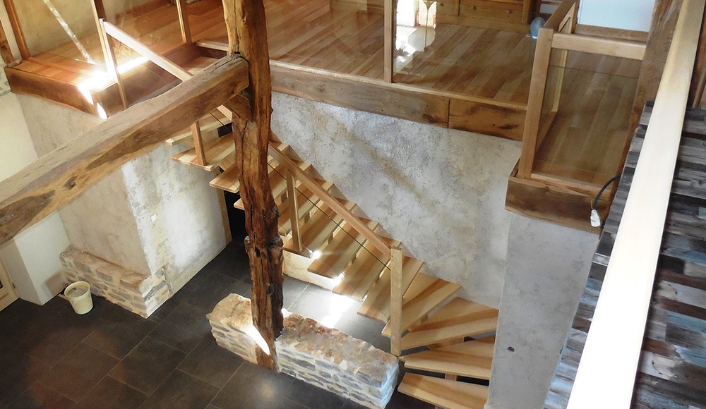 escalier en bois et mur en pierre